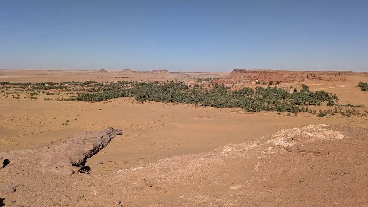 Paesaggio desertico in Algeria con formazioni rocciose all'orizzonte.