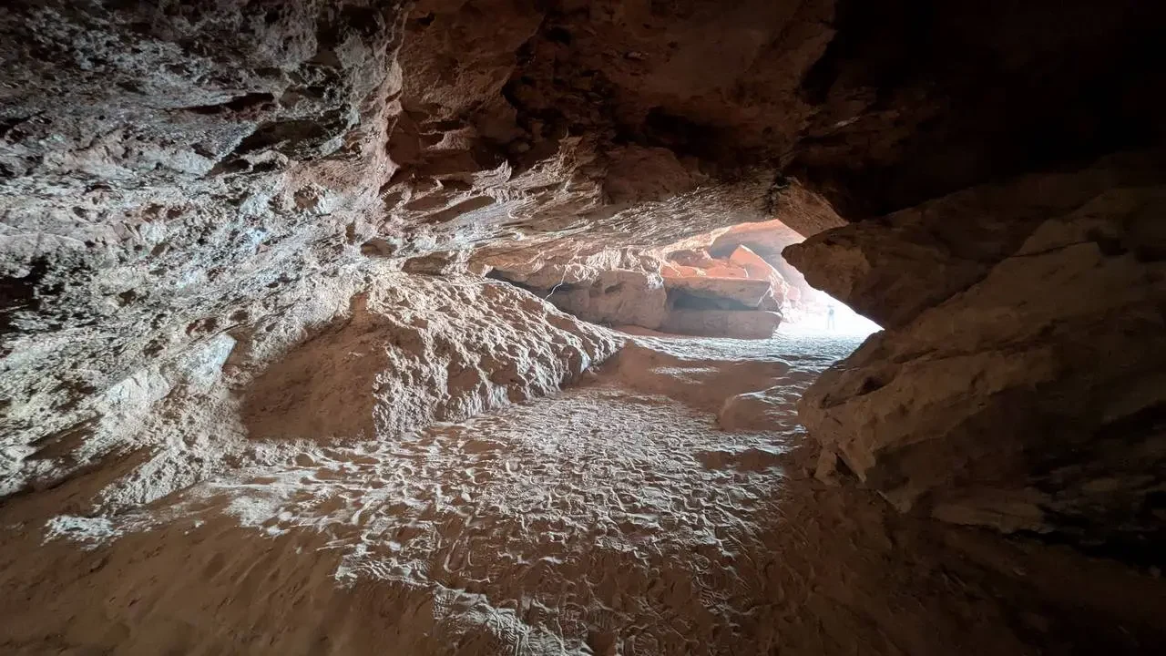 Interno di una grotta allagata con acqua che scorre tra le rocce.