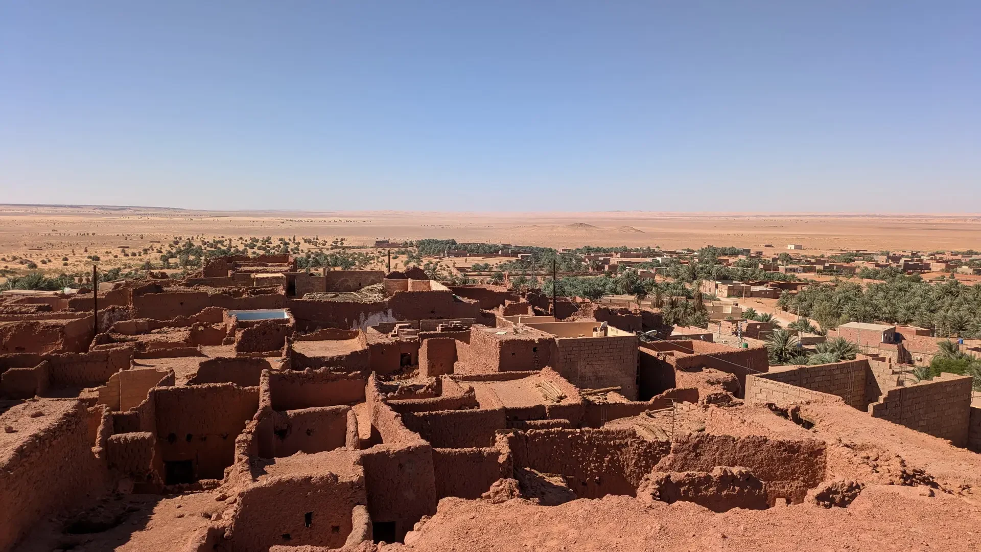 Un paesaggio desertico con abitazioni in terra cotta sotto un cielo limpido.