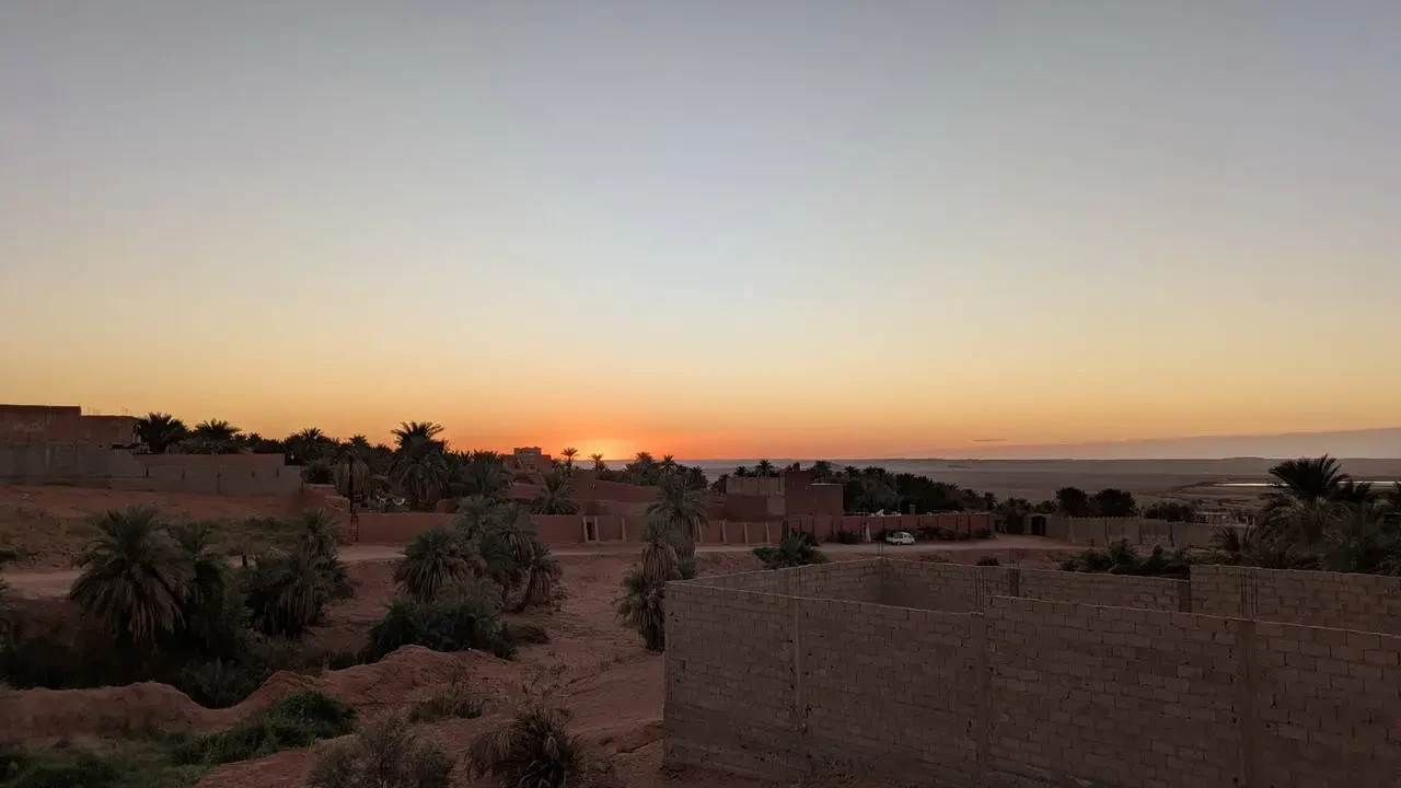 Tramonto sul paesaggio in Algeria con strutture in mattoni a vista.