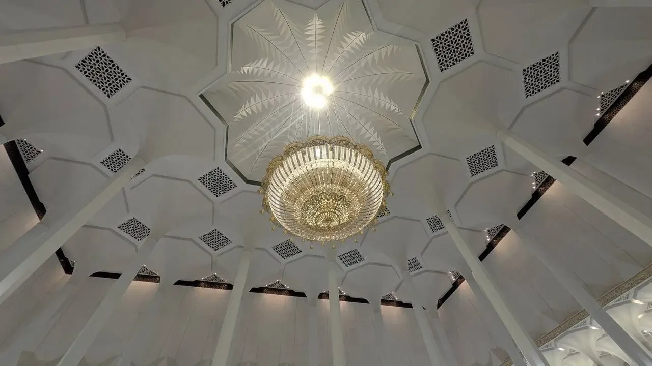 Interno sontuoso con soffitto decorato e lampadario di cristallo in un edificio algerino.