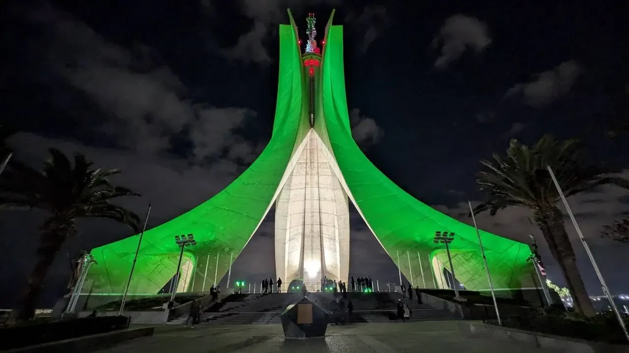 La memoria dei martiri di Algeri è illuminata da una struttura verde e bianca di notte.