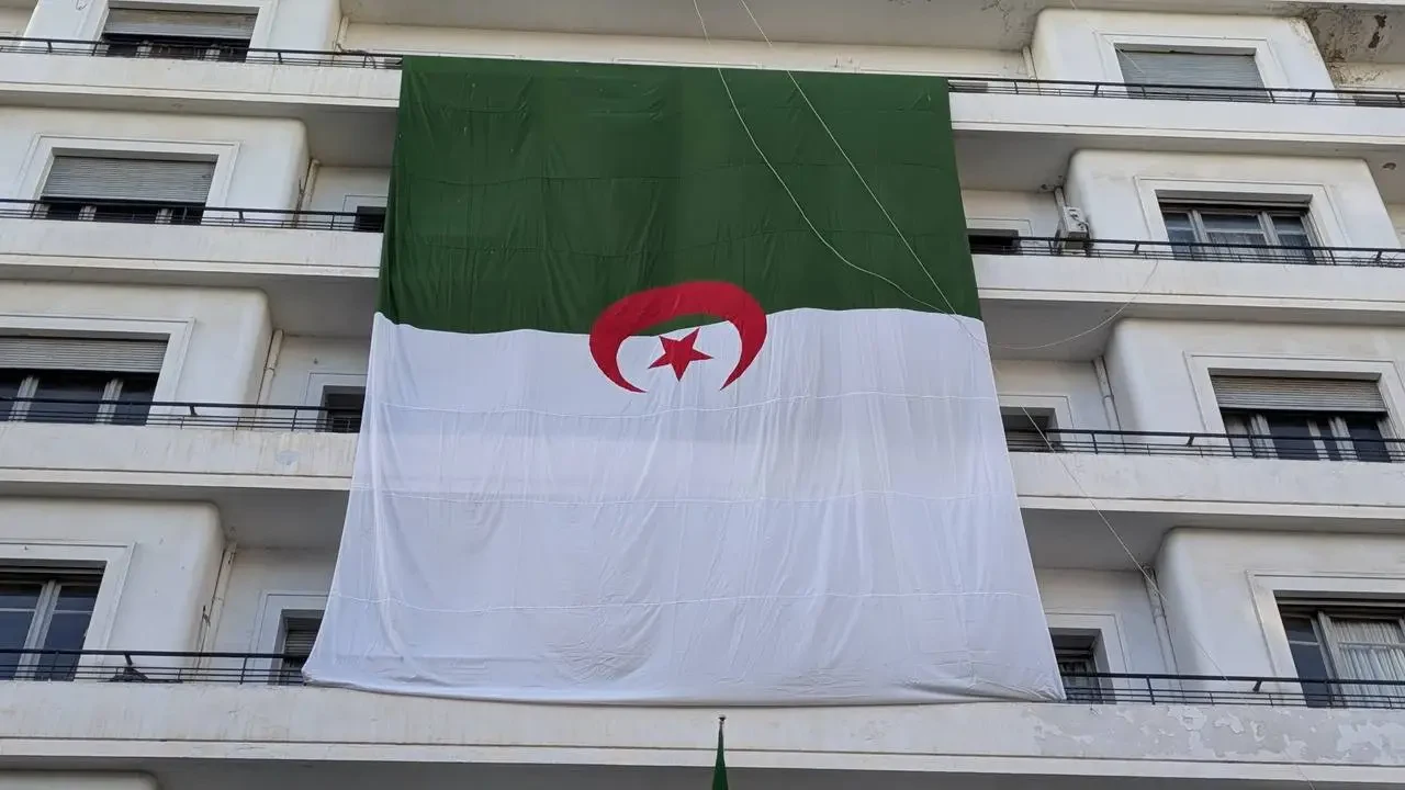 La bandiera algerina sventola davanti a un edificio.