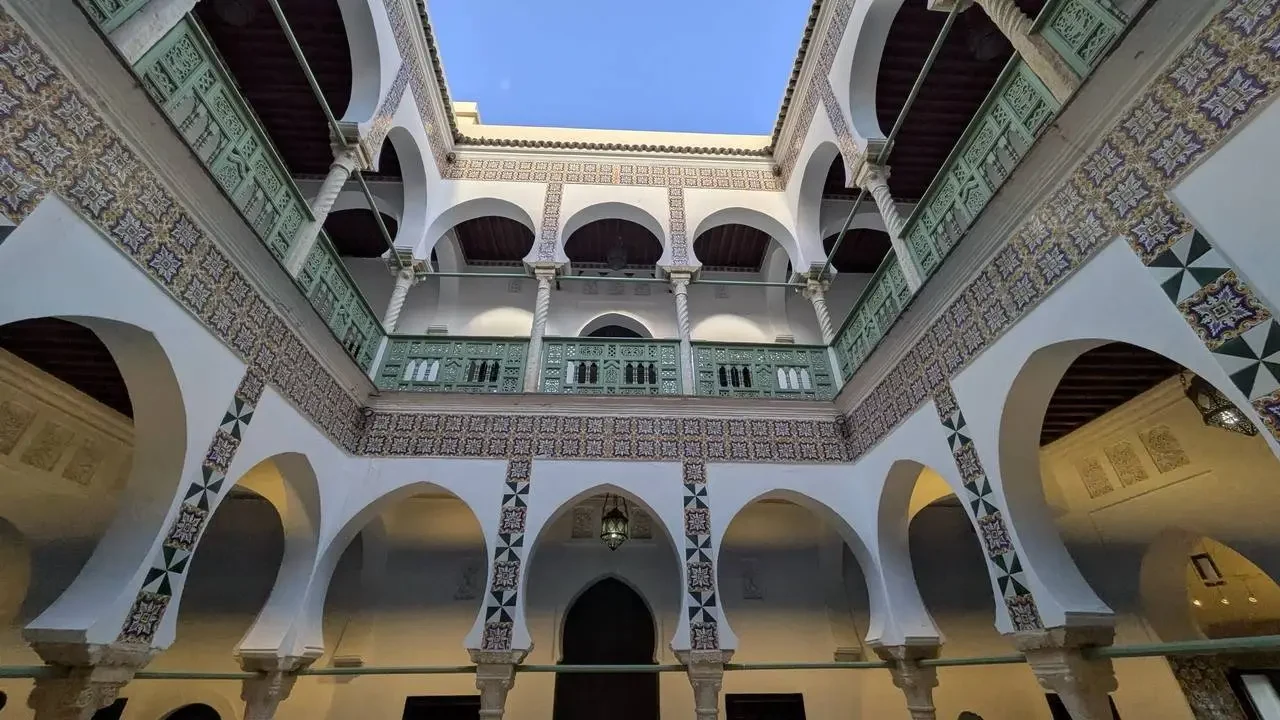Facciata architettonica con archi e balconi decorati.