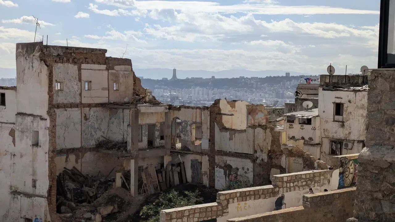 Vista panoramica della Casbah di Algeri con edifici in rovina in primo piano.