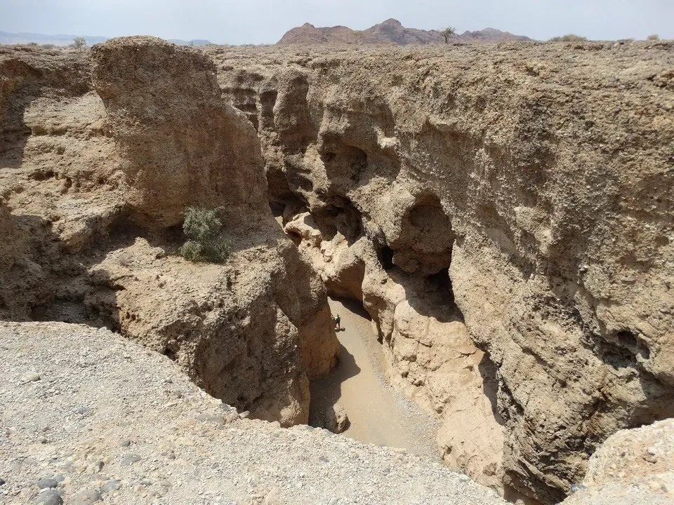 Un canyon secco e roccioso si estende attraverso un paesaggio arido.