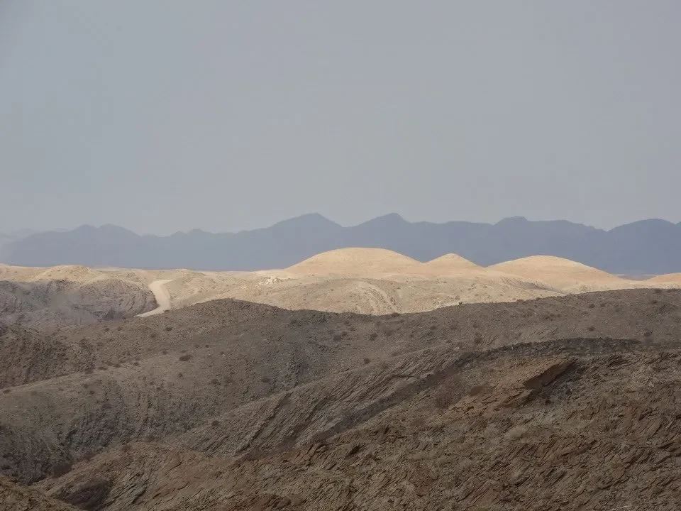 Paesaggio arido del deserto con colline ondulate all'orizzonte.