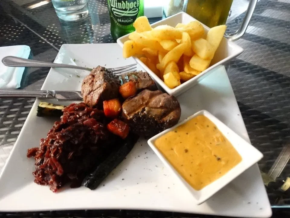 Aperitivo in un contesto africano con cibo servito all'aperto.