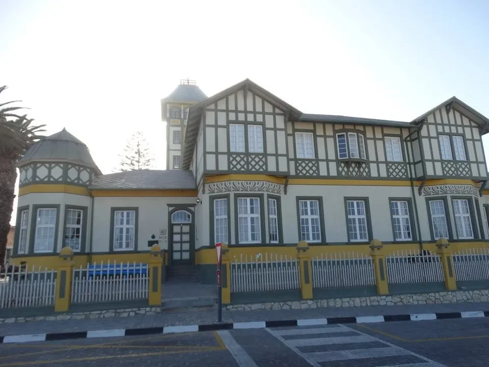 Una casa coloniale in stile architettonico si trova davanti a una recinzione in pietra.