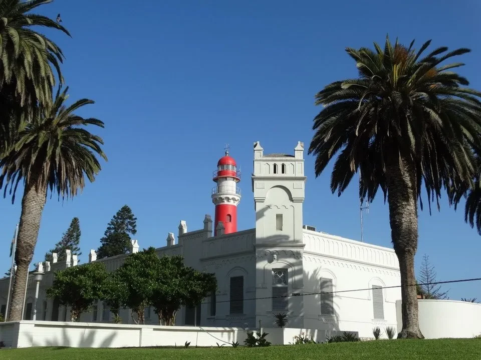 Edificio bianco con torre rossa in un paesaggio arido.
