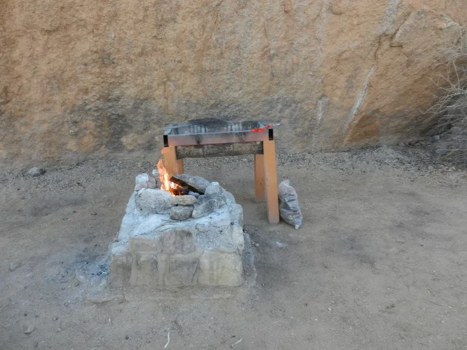 Un fuoco da campo arde su una roccia nel deserto africano.