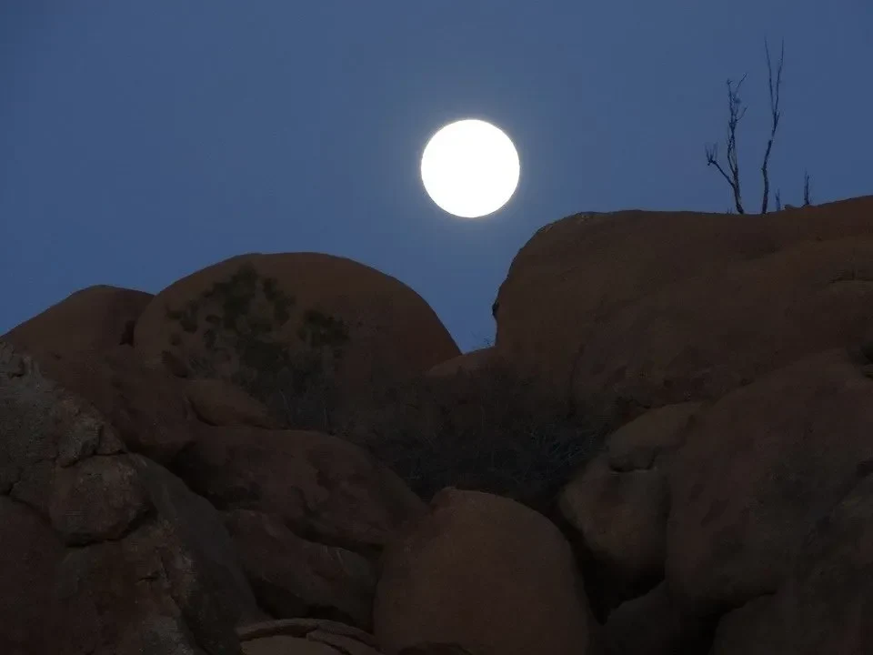 Un grande sole appare sopra le rocce aride del paesaggio africano.