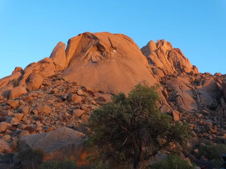 Rocce rosse e rocciose dominano il paesaggio sotto un cielo azzurro. Rocce rosse e rocciose dominano il paesaggio sotto un cielo azzurro.