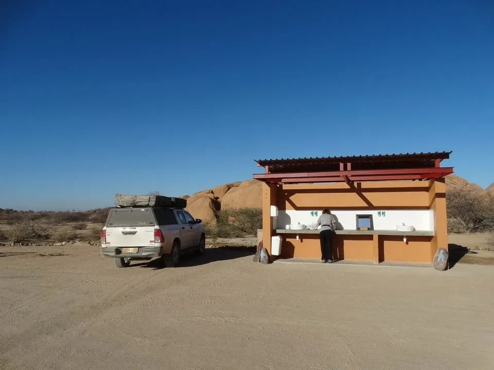 Un piccolo chiosco rustico si trova in un paesaggio arido del Namib o della regione circostante.
