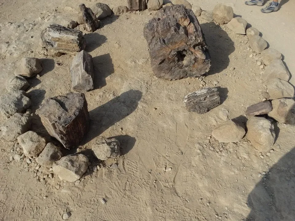 Rocce e massi antichi sono disposti su un terreno sabbioso in un paesaggio africano.