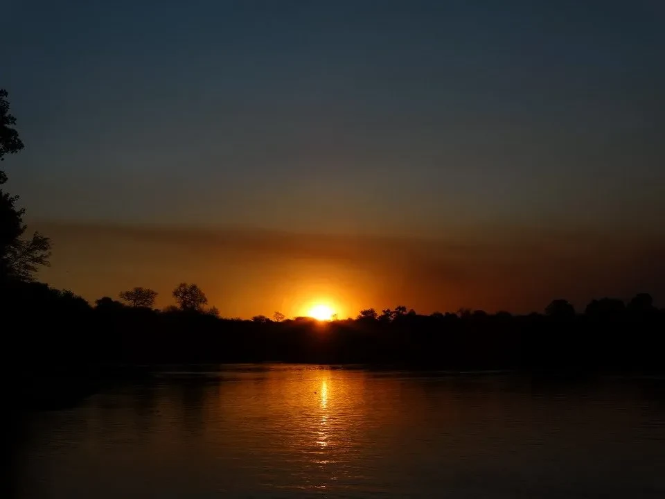 Tramonto del sole riflesso sull'acqua in una savana africana.