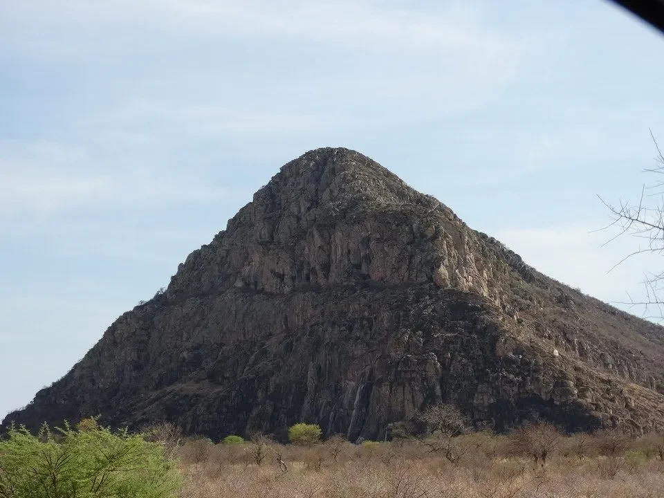 Una grande formazione rocciosa montuosa domina il paesaggio africano.