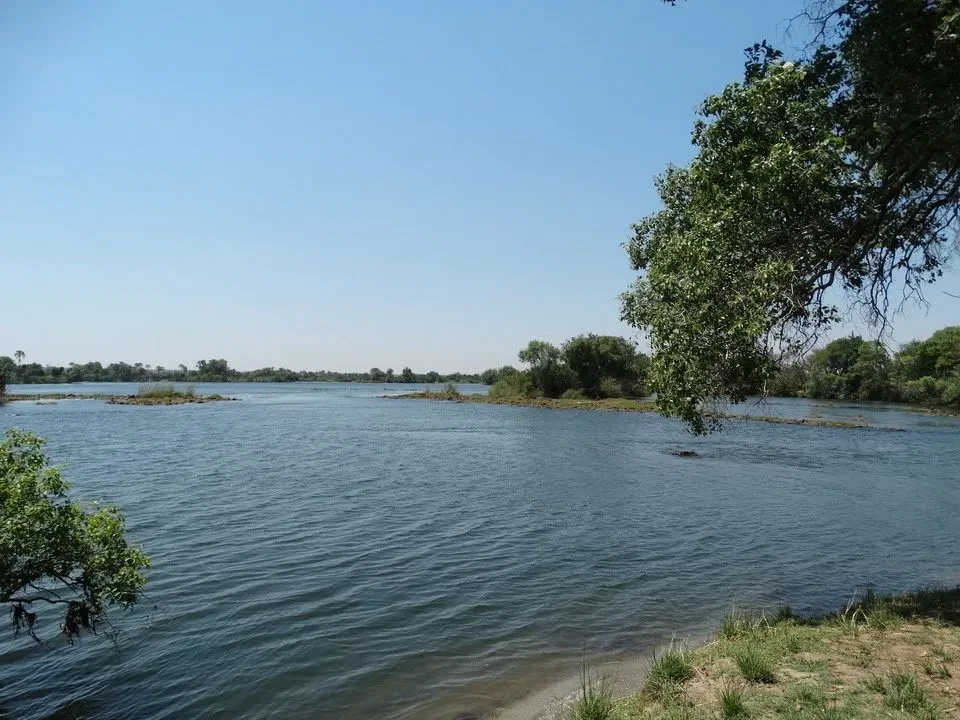 Un fiume tranquillo attraversa un paesaggio arido in Namibia, Botswana e Zimbabwe.
