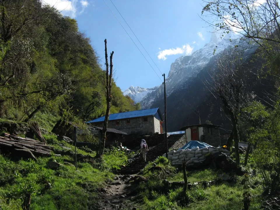 Sentiero rurale e abitazioni in una valle alpina nepalina.