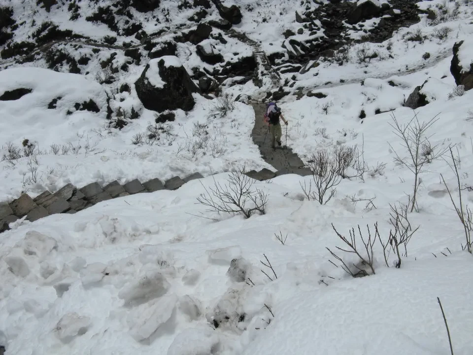 Una persona cammina attraverso un paesaggio innevato delle montagne del Nepal e del Tibet.