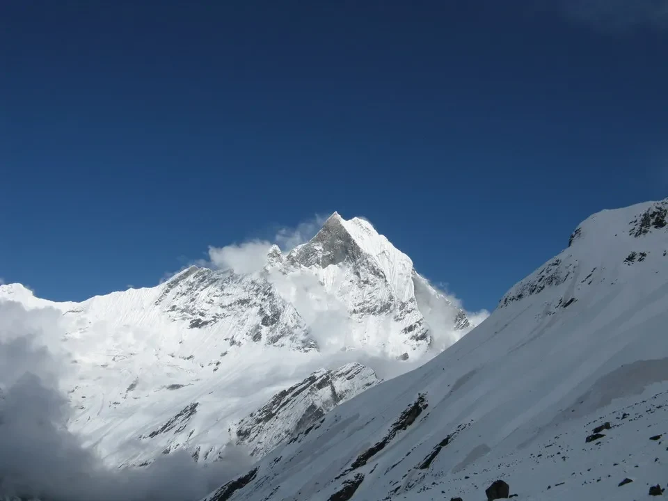 Paesaggio montano innevato con vette rocciose sotto un cielo azzurro. Paesaggio montano innevato con vette rocciose sotto un cielo azzurro.