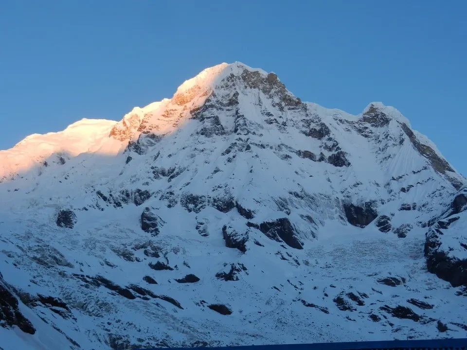 Una montagna innevata con luce dorata al tramonto domina il paesaggio.