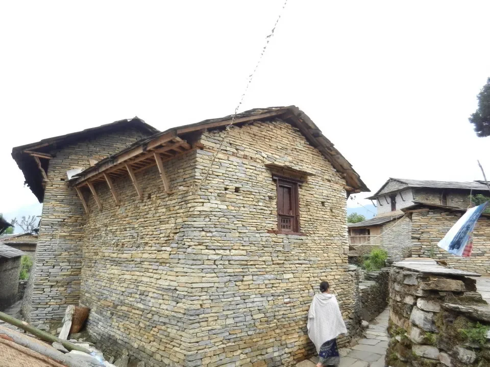 Un edificio tradizionale in pietra lungo un sentiero montano in Nepal o Tibet.