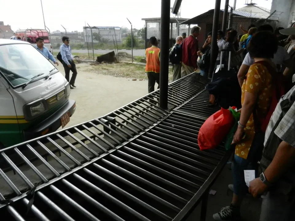 Persone aspettano i bagagli all'aeroporto di Kathmandu.