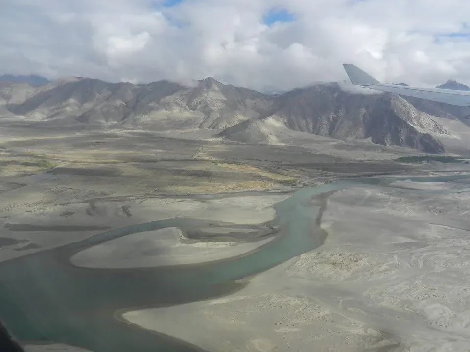 Atterraggio di un aeromobile su una vasta pianura montuosa in Nepal o Tibet.