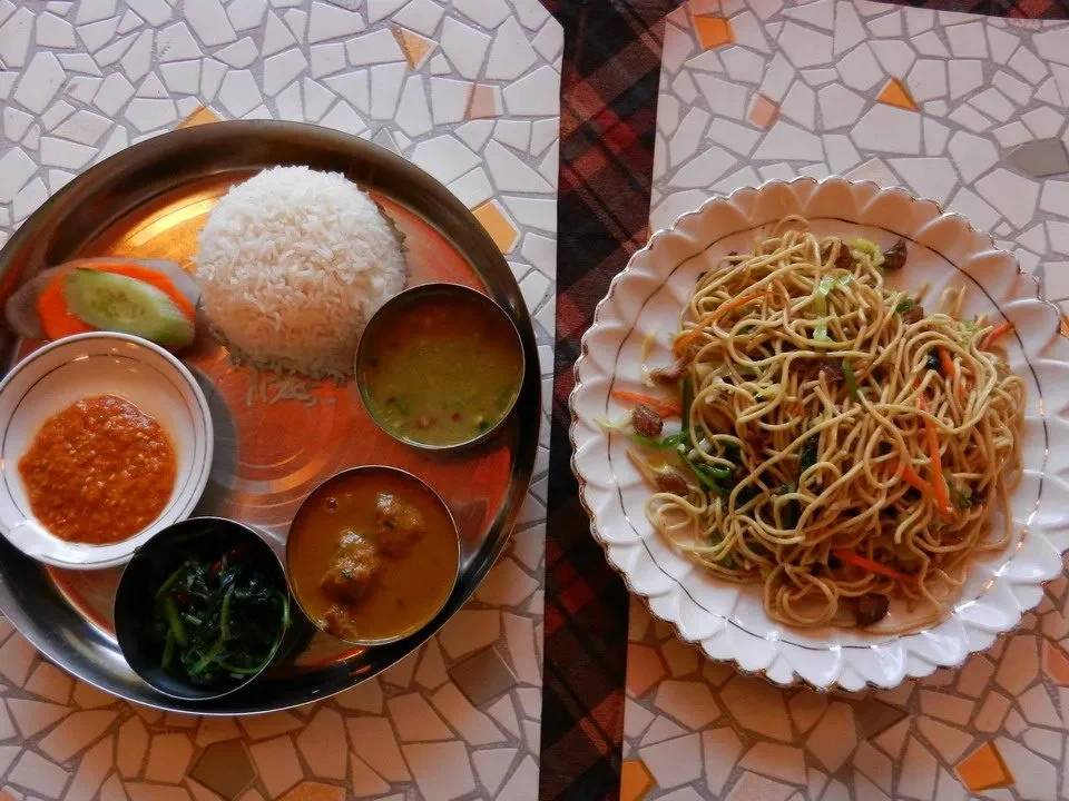 Un piatto di cibo tradizionale nepalese o tibetano è disposto su una tavola.