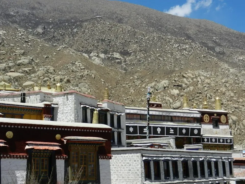 Architettura tradizionale tibetana con montagne sullo sfondo.