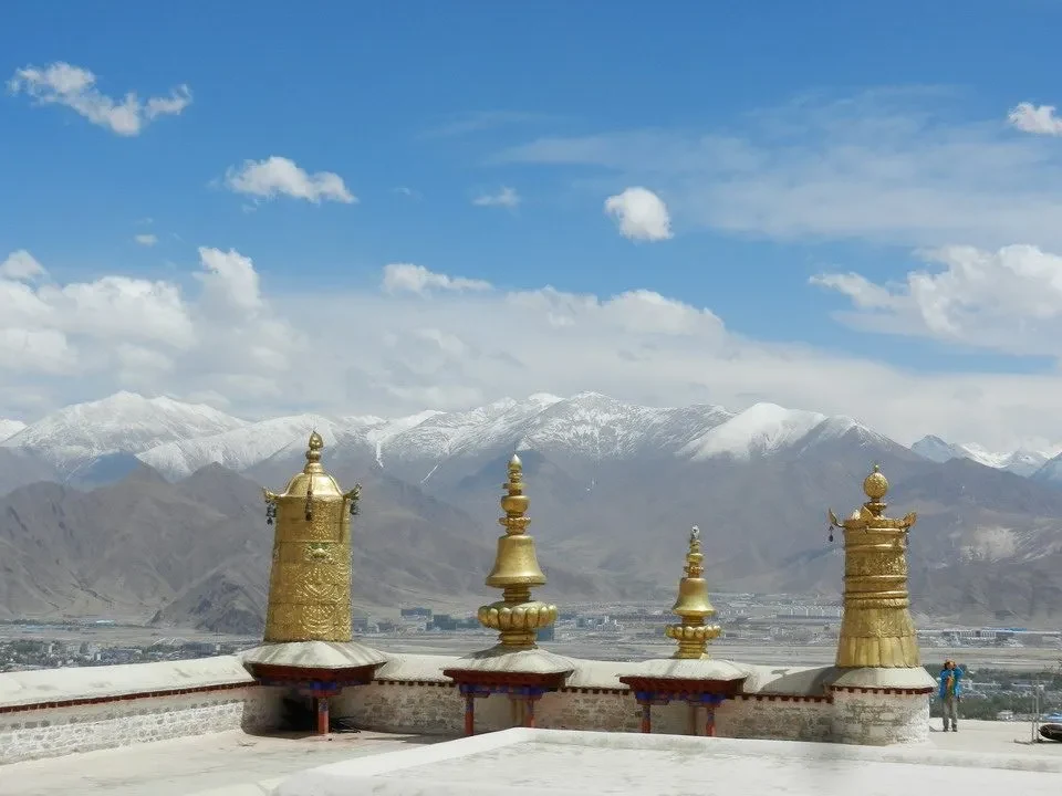 Monasteries in Lhasa, Tibet, are set against a backdrop of snow-capped mountains.