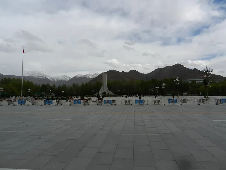 Vista ampia del Parco del Popolo a Lhasa con montagne sullo sfondo.