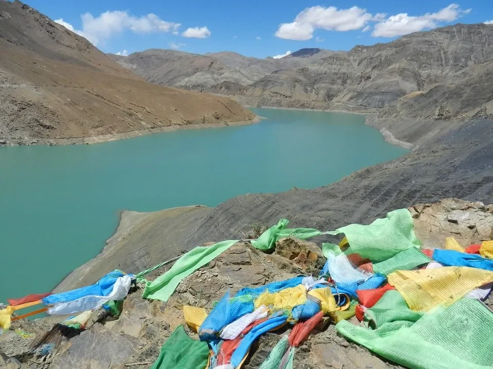 Un paesaggio montano con un lago turchese incastonato tra montagne aride.