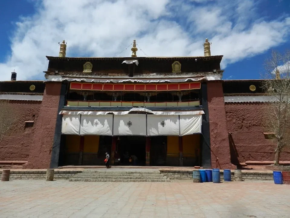 La facciata rossa del monastero di Gyantse nel Tibet è vista con un cortile antistante.
