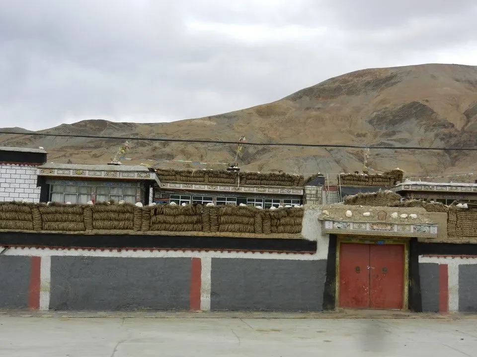 Un edificio tradizionale in stile tibetano si trova in un paesaggio montano.