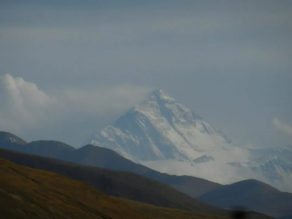 Una montagna innevata si staglia contro il cielo in un paesaggio montano del Nepal e del Tibet.