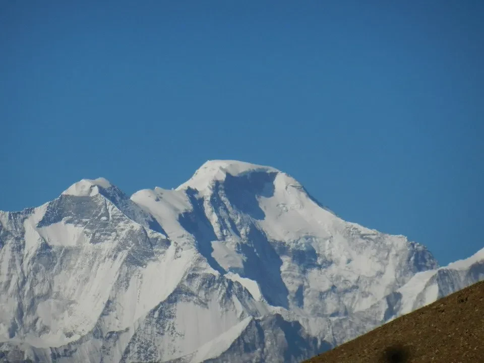 Immagine panoramica delle montagne innevate del Nepal e del Tibet sotto un cielo azzurro.