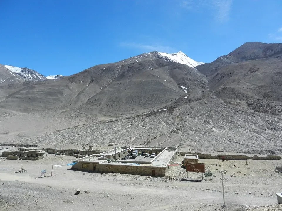Monastero e guestifrittura vicino a un monastero in Nepal e Tibet con montagne innevate sullo sfondo.