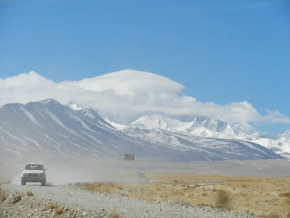 Un veicolo attraversa un paesaggio montano innevato in Nepal o Tibet.