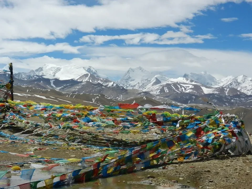 Un fiume colorato scorre attraverso un paesaggio montano innevato in Nepal e Tibet.