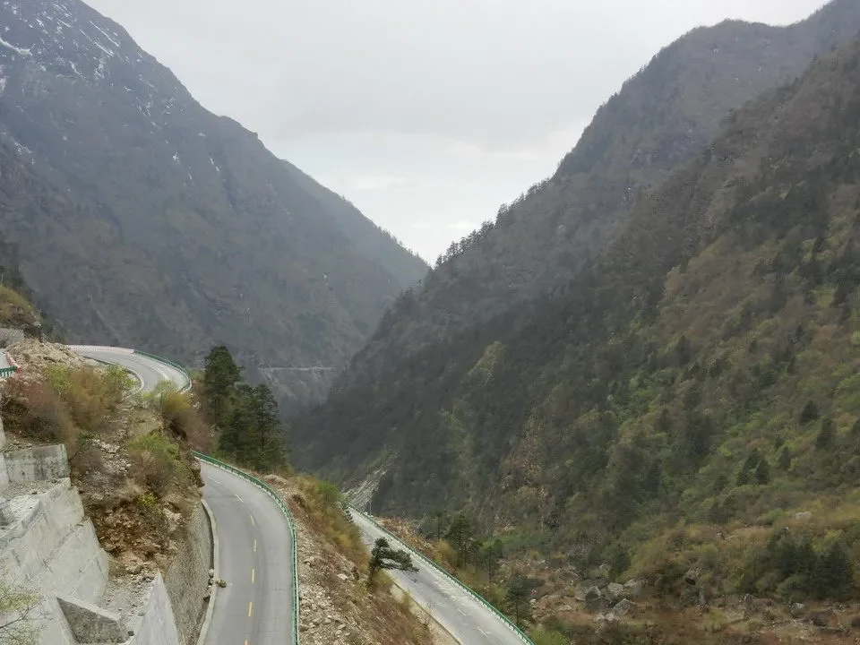 Una strada serpeggia attraverso un paesaggio montano innevato in Nepal e Tibet.