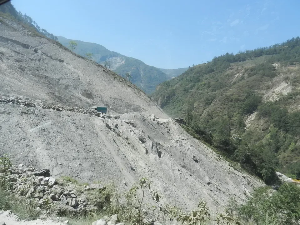 Pendii montani rocciosi con vegetazione lungo una valle.