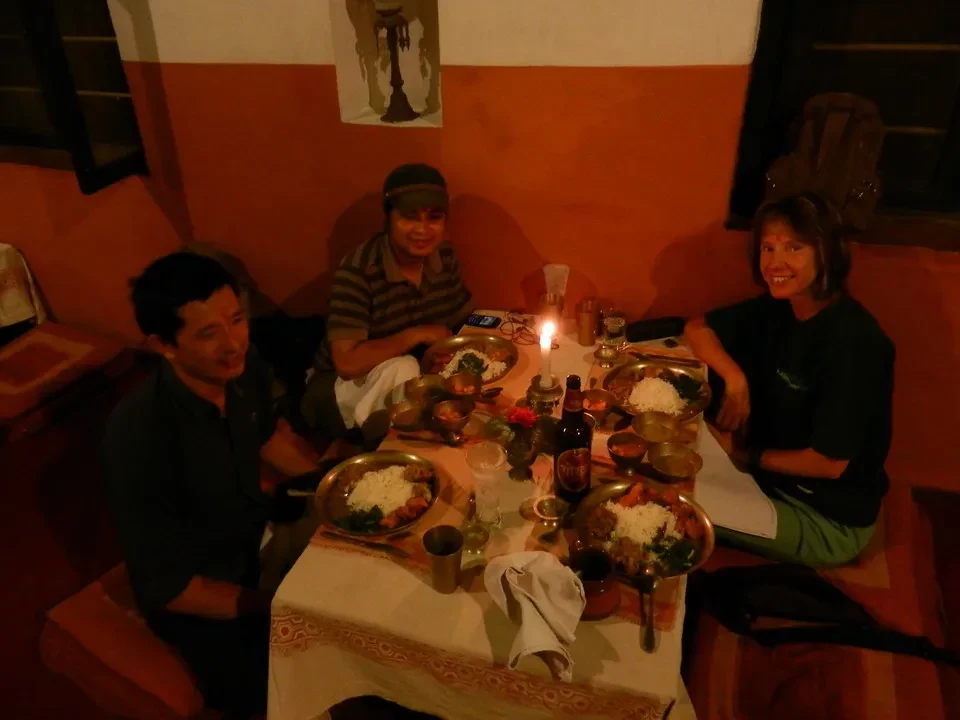 Un gruppo di persone mangia una cena in un ambiente interno caldo.