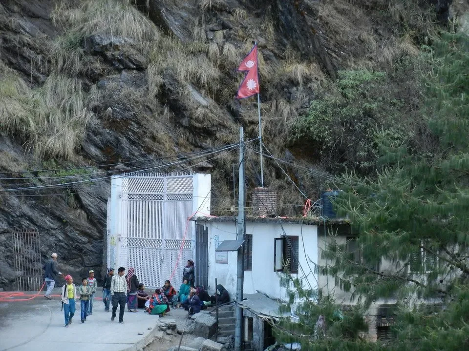 Un ponte di legno attraversa un paesaggio montano in Nepal o Tibet.
