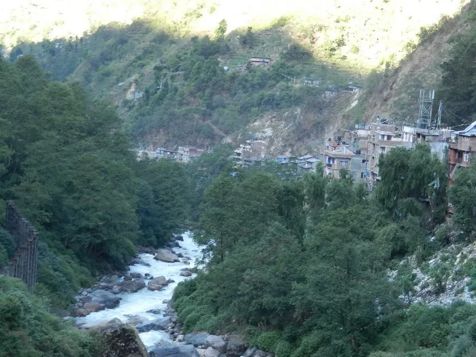 Un fiume scorre tra le montagne verdi e gli edifici in Nepal e Tibet. Un fiume scorre tra le montagne verdi e gli edifici in Nepal e Tibet.