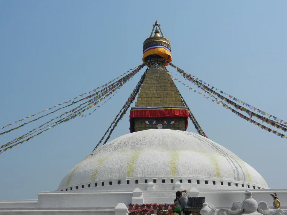 Tempio buddista con cupola bianca decorata da striscioni sventolanti in Nepal e Tibet.