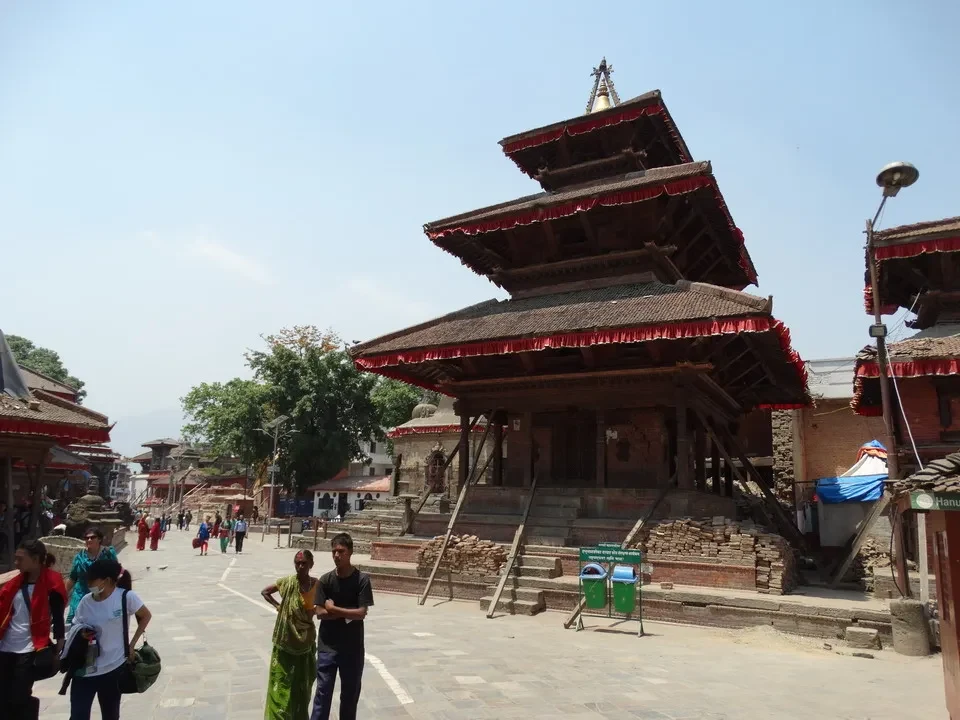 Una piazza del durbar a Kathmandu con edifici tradizionali tibetani in primo piano.