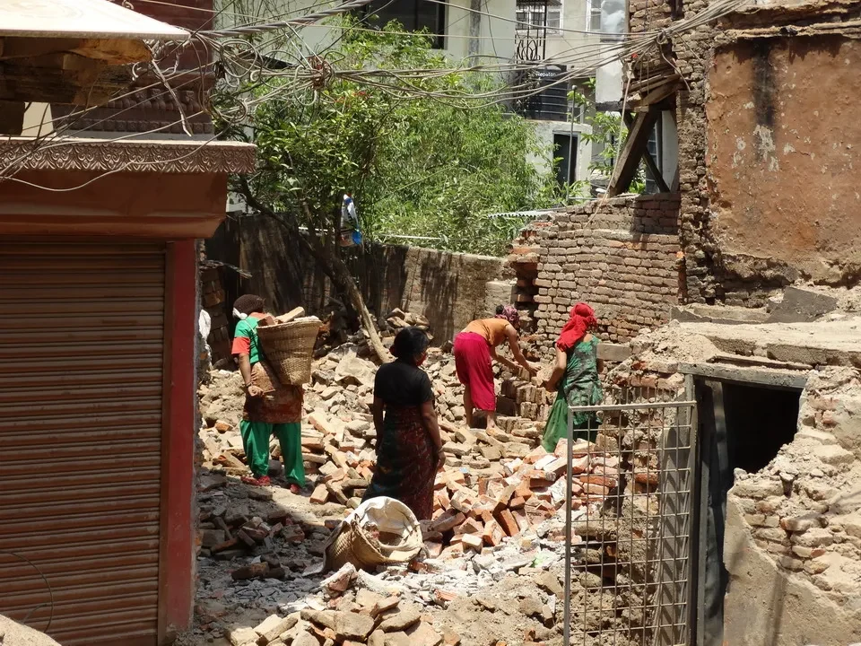 Lavoratori costruiscono in una strada urbana con edifici in mattoni a vista.