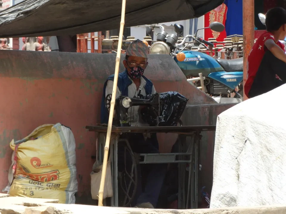 Un uomo è seduto su una piattaforma con moto in un contesto di viaggio in Tibet e Kailash vicino a Kathmandu.